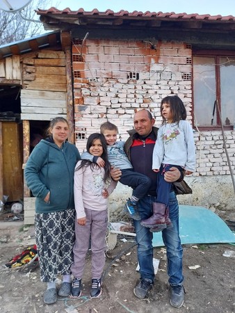 Yamur with her family outside their hose in Bulgaria